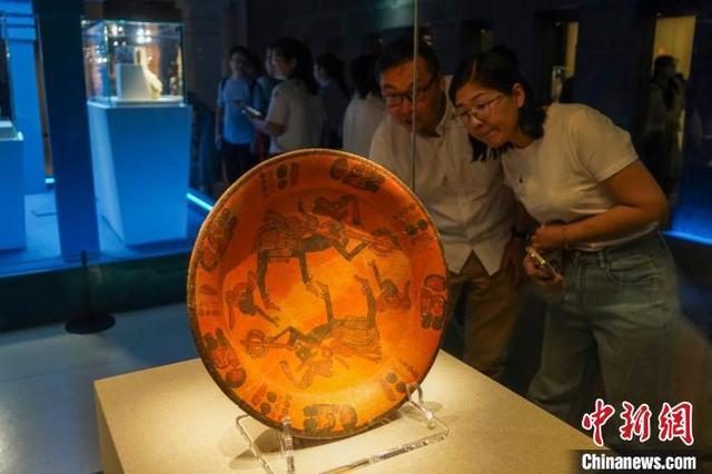圖為觀眾參觀展品象征性圖案彩繪陶盤。范曉恒 攝