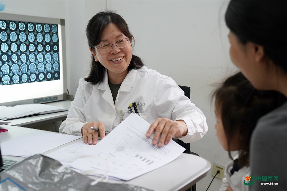 儿童神经内科主任医师王三梅在门诊与患者家属沟通军娃病情。中国军网记者孙悦 摄