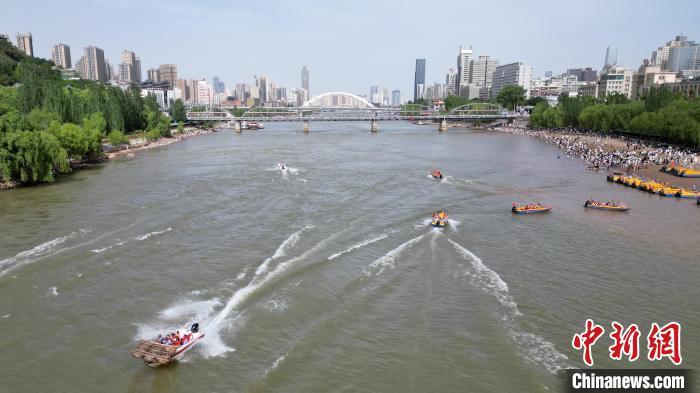 5月31日，甘肃兰州，游客乘坐快艇游览黄河。端午假期首日，众多游客选择在黄河兰州段的茶摊喝茶，乘坐羊皮筏子、快艇游览黄河。（无人机照片）中新社记者　九美旦增　摄