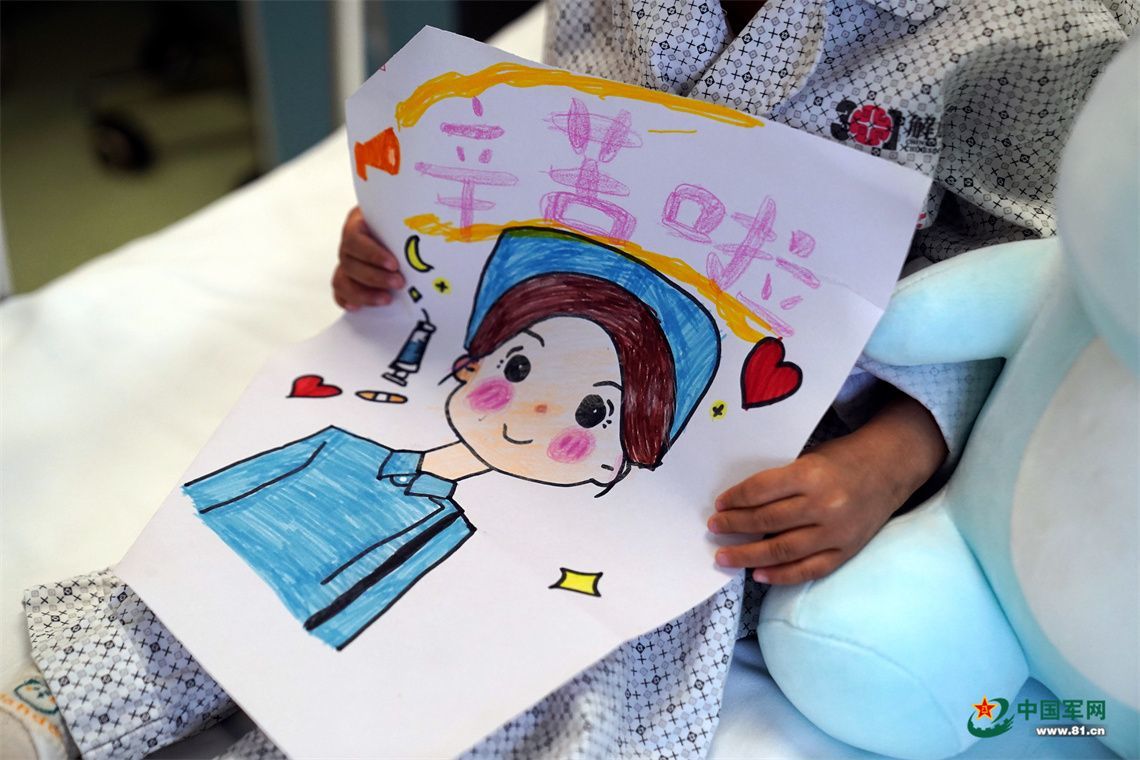军娃甜甜拿着自己的画作《守护星》。中国军网记者孙悦 摄