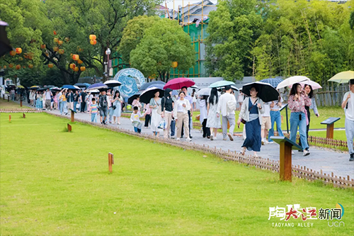 游客雨中漫步陶阳里（珠山文旅 供图）