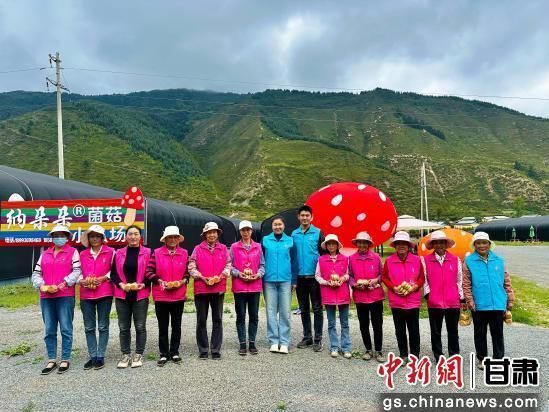 图为张纳欣（左七）和卓尼县农户在纳朵朵菌菇小农场的合影　受访者供图