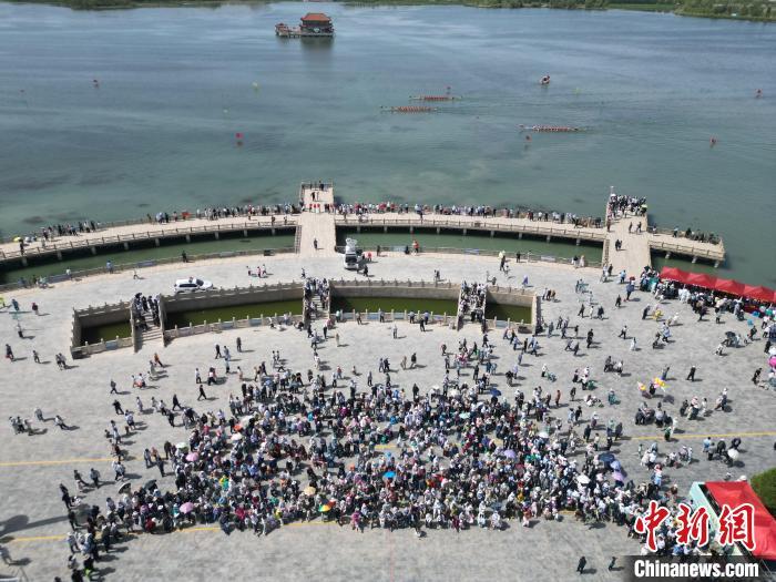 5月31日，2025年全国“我们的节日&middot;端午”主题文化活动在甘肃省张掖市高台县大湖湾崇文楼广场启幕。作为全国六个主会场之一的高台县，“龙舟竞渡庆端午”是该县连续传承近20年的一项传统文化盛会。图为2025年全国“我们的节日&middot;端午”主题文化活动现场。（无人机图片）戴文昌　摄