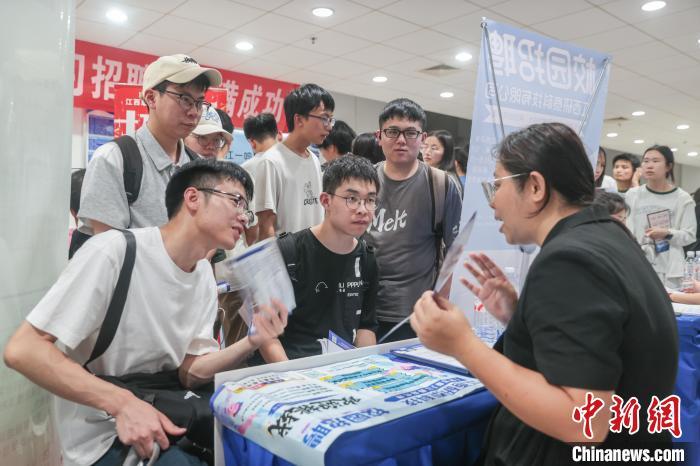 圖為招聘會現場，求職者在同企業招聘人員交流。中新社記者 劉力鑫 攝