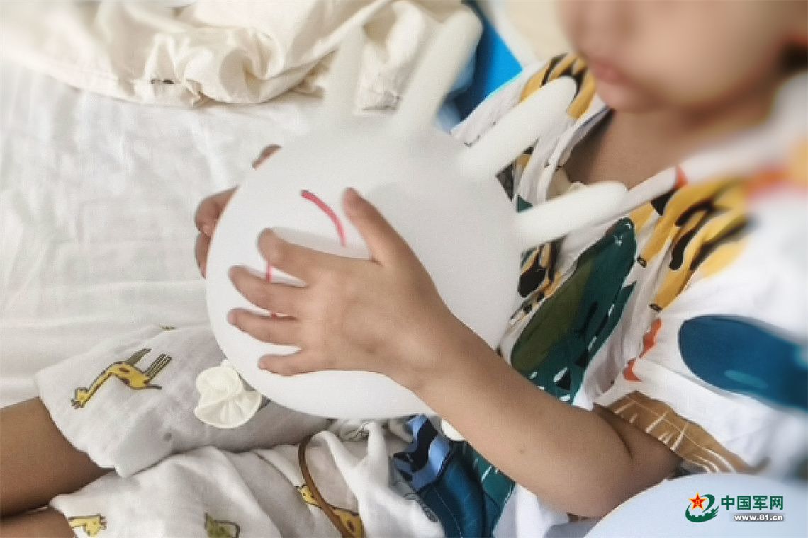 军娃小优抱着“手套气球”。周珊聿 摄