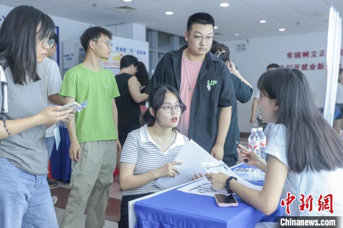 圖為招聘會現場，求職者在同企業招聘人員交流。中新社記者 劉力鑫 攝