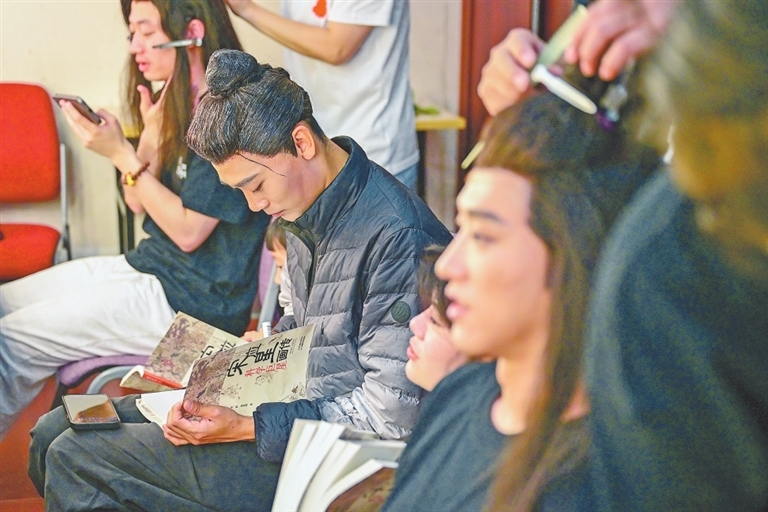 老年宋应星扮演者马蛟龙,正在《科学巨星宋应星画传》书上签名。