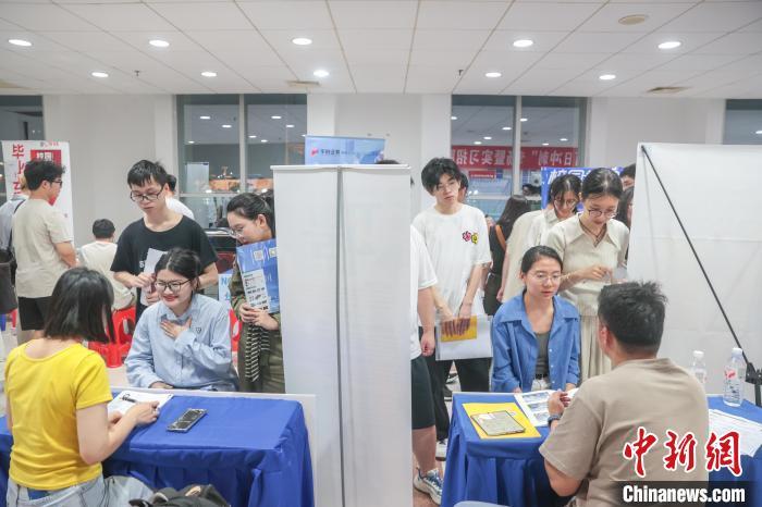 圖為招聘會現場，求職者在同企業招聘人員交流。中新社記者 劉力鑫 攝