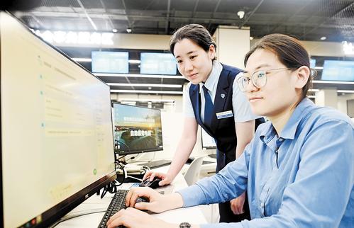 5月22日，雄安新区政务服务中心，工作人员协助群众通过雄安新区政务服务网向“雄小智”发送需求。本组图片由本报记者刘光昱摄