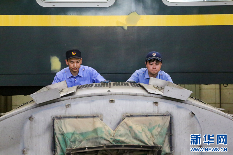 5月30日,在检修库内,车辆电工使用运转小车将空调机组推送至检修作业区。新华网发(程锦龙 摄)