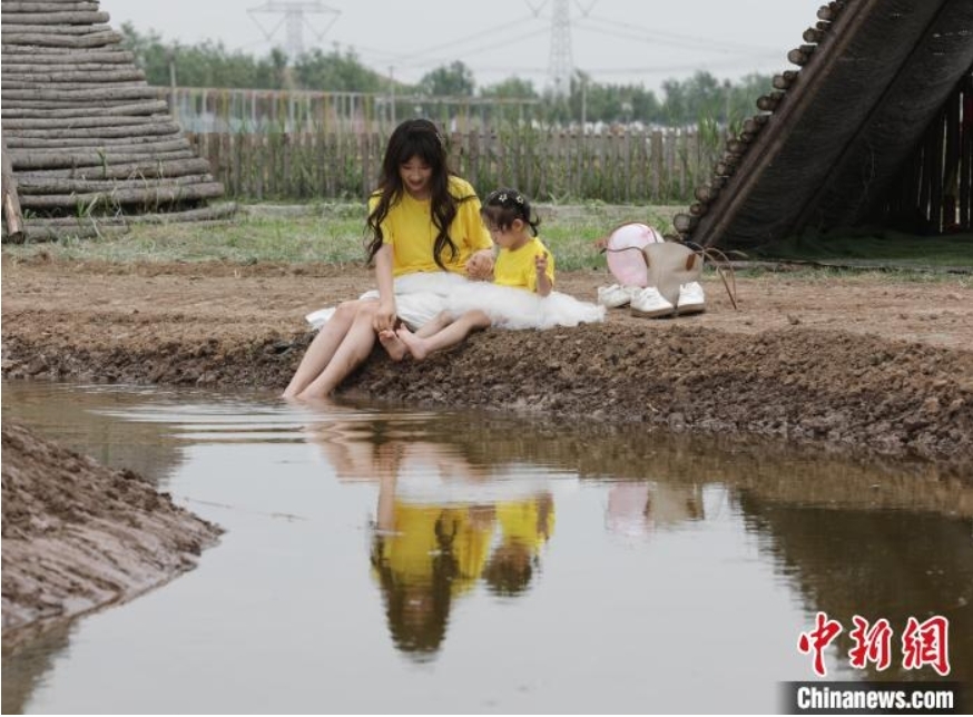 稻田寻宝、牧场奇遇、插秧比赛……端午节当天，在河北省沧县兴济镇南堤村盐碱稻田乐园里，200多个家庭参与“盐碱稻田寻宝季”活动，感受别样端午。图为游客在河北省沧县兴济镇南堤村的盐碱稻田乐园中戏水。 田博 摄