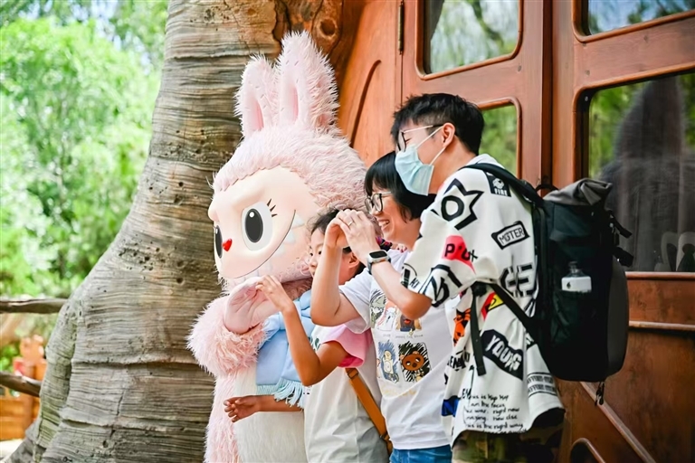 游客在泡泡玛特城市乐园与人偶互动。 企业供图