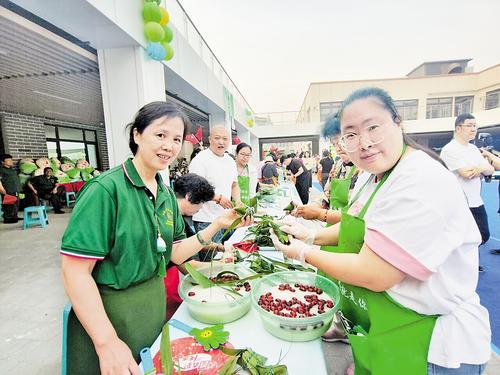 5月29日下午，唐山市路南区开展新时代邻里节活动，来自10个镇街的居民在建国里商业街参加包粽子大赛。 本报记者 赵泽众摄