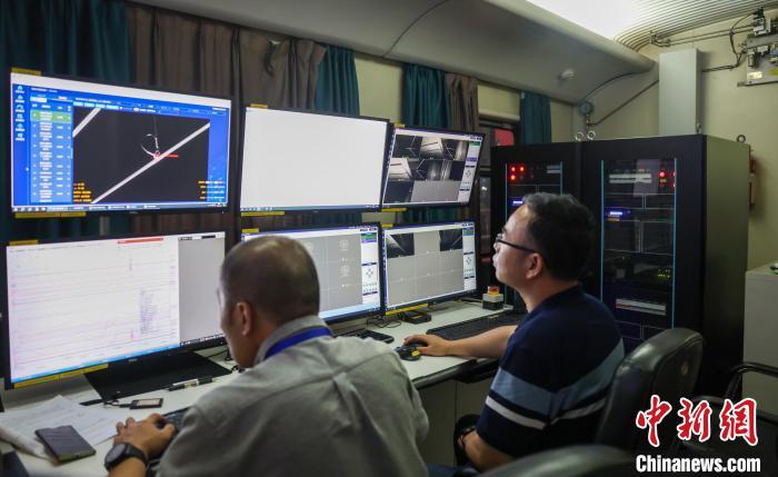 图为6月4日凌晨，昌九高铁先行开通段联调联试工作人员正在查看接触网运行状态。李嘉辉 摄