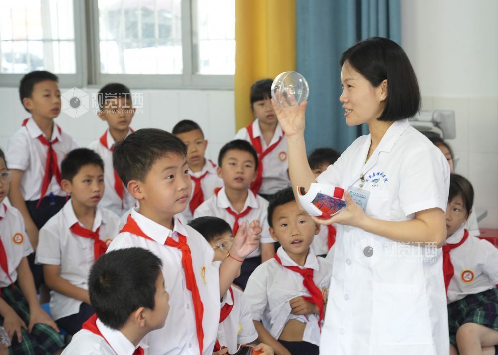 2025年6月5日,在江西省吉安市吉州区田侯路小学,眼科医生为学生讲解爱眼护眼知识。