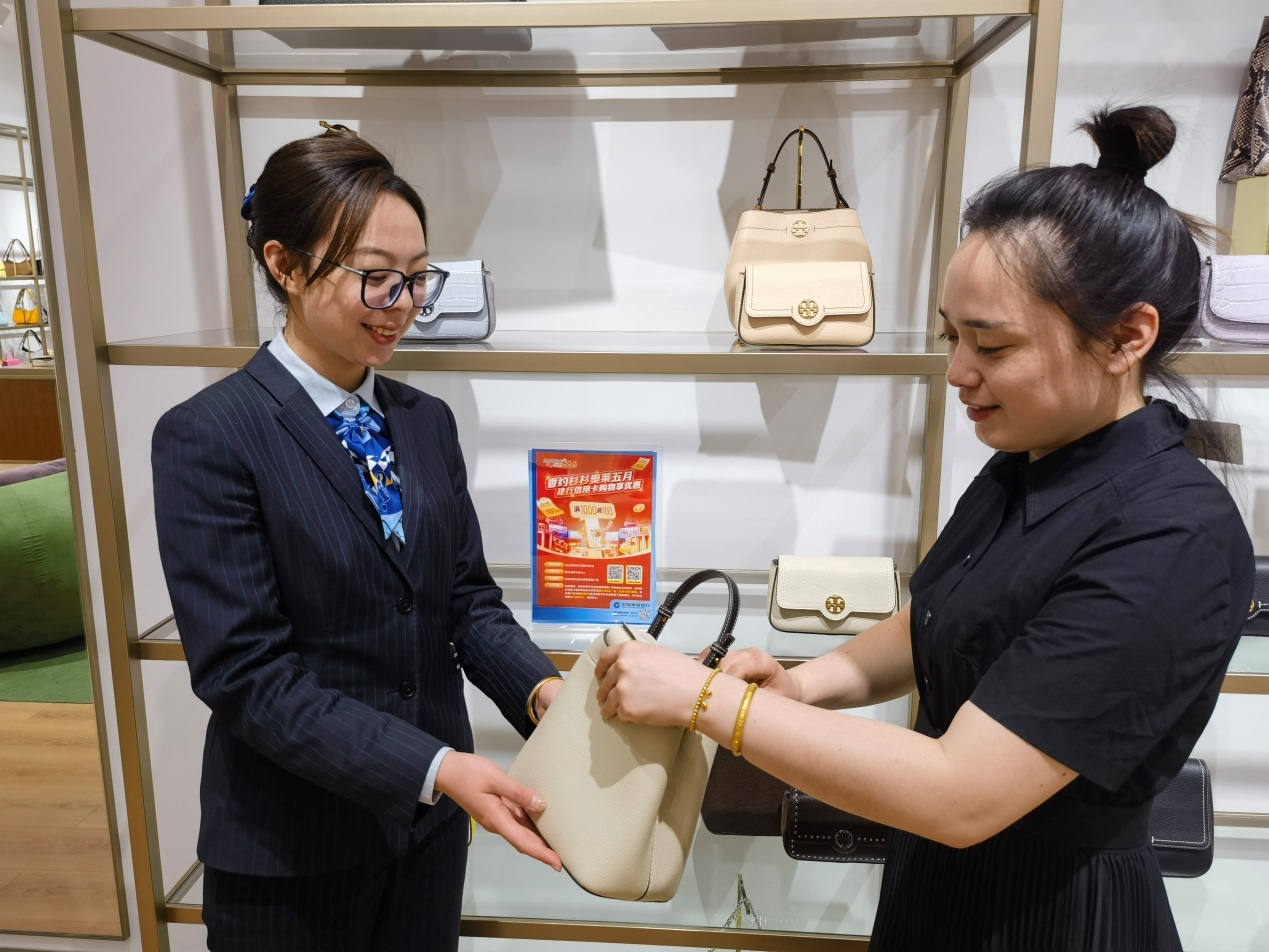 (建设银行呼兰支行工作人员为顾客讲解“龙卡信用卡66节”优惠政策)