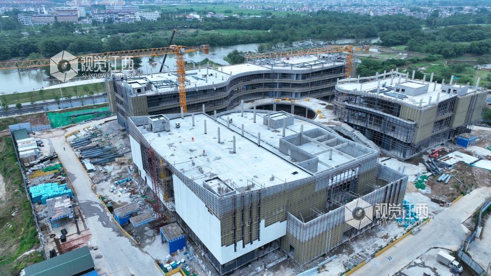 2025年6月5日,江西省遂川县文化产业中心项目施工进入竣工冲刺阶段,建筑工人正利用晴好天气抓紧幕墙等分项工程的建设。
