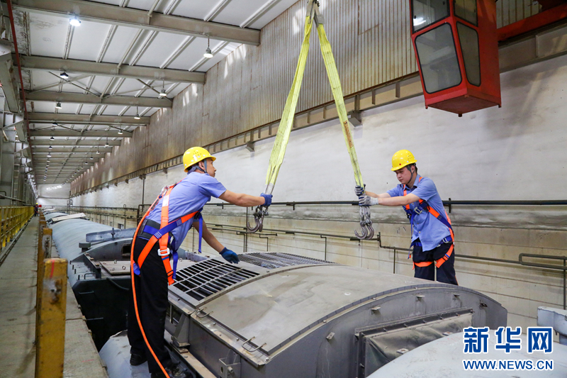 5月30日,在检修库内,车辆电工正在使用天车进行空调装置吊运作业。新华网发(李洪清 摄)
