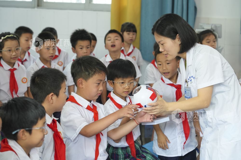 2025年6月5日,在江西省吉安市吉州区田侯路小学,眼科医生为学生讲解爱眼护眼知识。