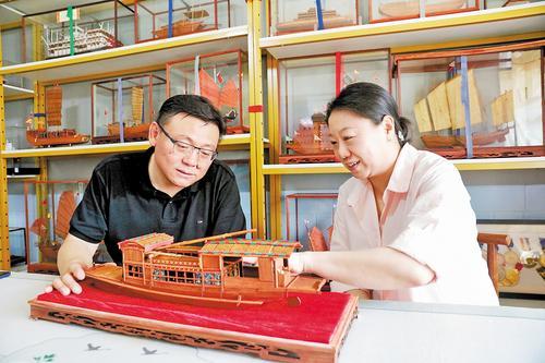 5月28日，张鼎（左）与妻子阚燕娜交流古船模制作技艺。 本报记者师源摄