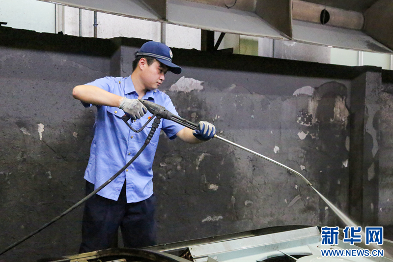 5月30日,车辆电工使用高压水枪对空调机组冷凝风机装置进行清洗作业。新华网发(李洪清 摄)