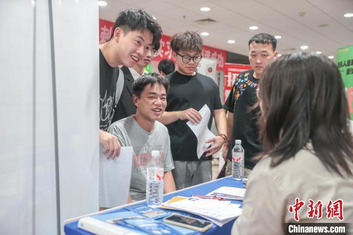 圖為招聘會現場，求職者在同企業招聘人員交流。中新社記者 劉力鑫 攝