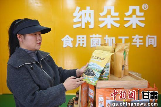 图为张纳欣正在介绍该公司研发的木耳新产品　九美旦增　摄