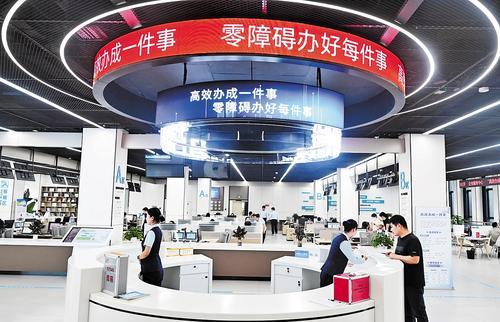 5月22日，雄安新区政务服务中心，工作人员在解答群众咨询。在服务大厅内，“高效办成一件事”“零障碍办好每件事”标语随处可见。