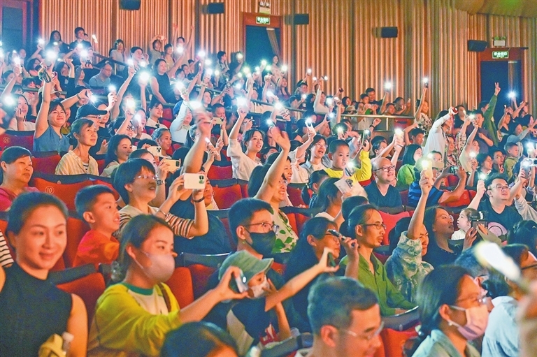 演出现场气氛热烈,观众打开手机灯和演员们互动。