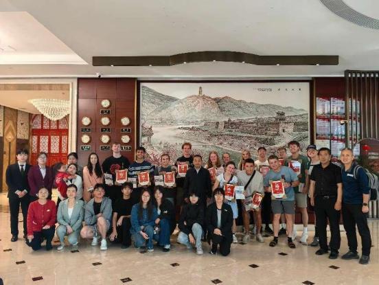 （临别时马逸飞代表红星园向外国学生赠送斯诺剪纸画像纪念品）