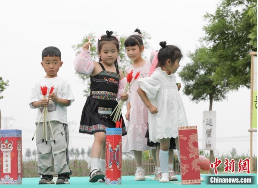 稻田寻宝、牧场奇遇、插秧比赛……端午节当天，在河北省沧县兴济镇南堤村盐碱稻田乐园里，200多个家庭参与“盐碱稻田寻宝季”活动，感受别样端午。图为小游客在河北省沧县兴济镇南堤村的盐碱稻田乐园体验传统投壶游戏。 田博 摄