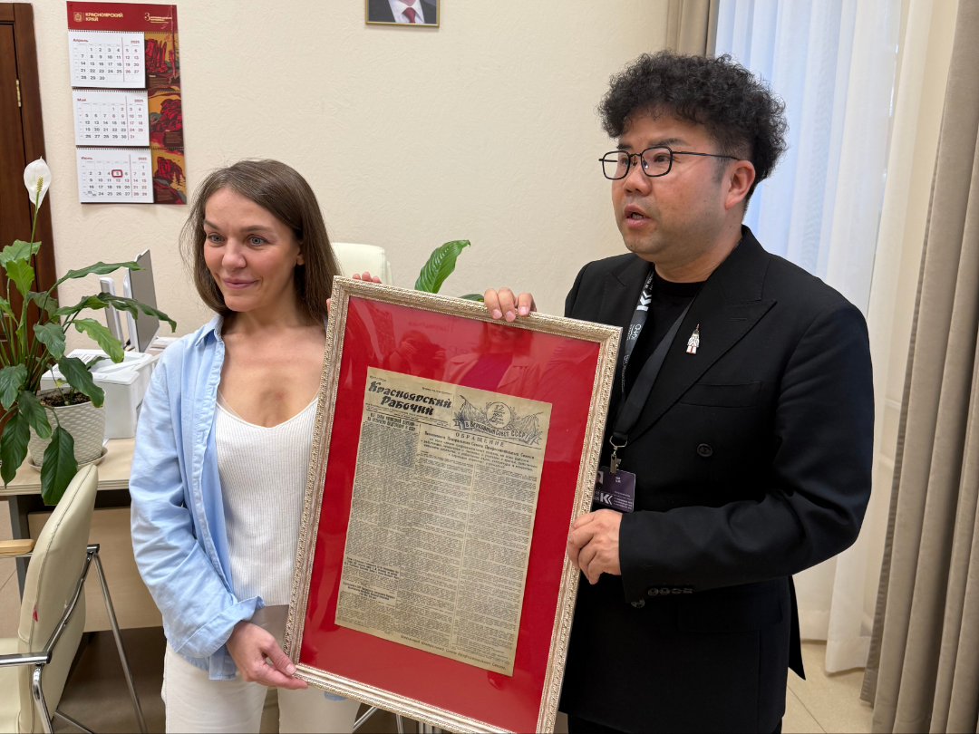 史佳(右)收到1950年2月25日出版的《克拉斯诺亚尔斯克工人报》报纸原件，上面报道了毛泽东主席访问克拉斯诺亚尔斯克等市时的新闻