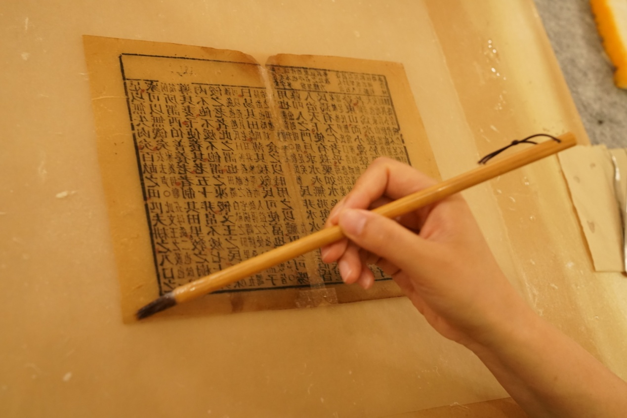 体验者对破损的古书籍扉页进行修复。（王继军摄）