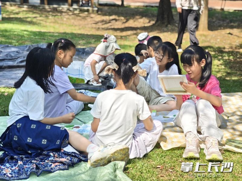 在西湖公园内，孩子们围坐一起在沉浸式创作