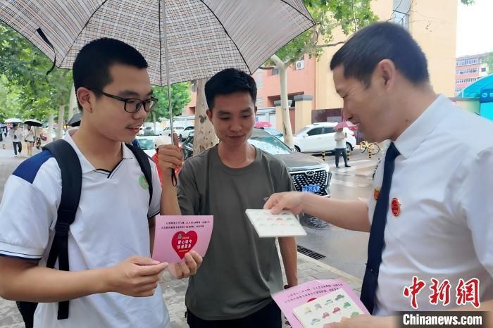 图为“的哥”吴群峰向考生赠送祝福卡。 梅镱泷 摄