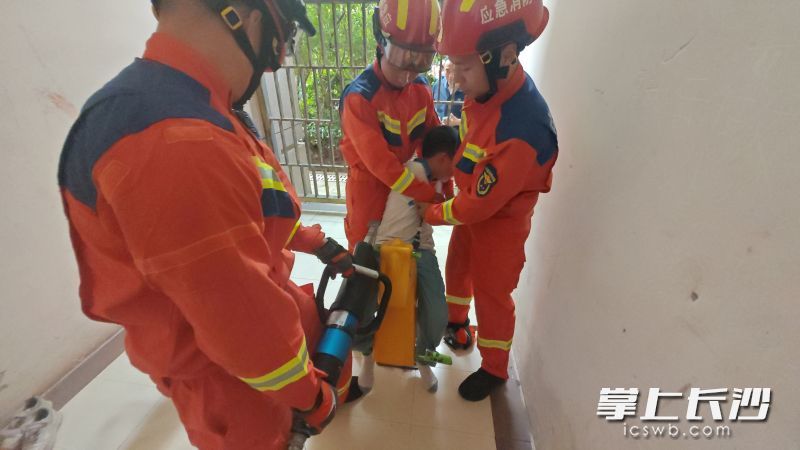 消防队员帮助小男孩脱困。 长沙晚报通讯员 杨慧 摄