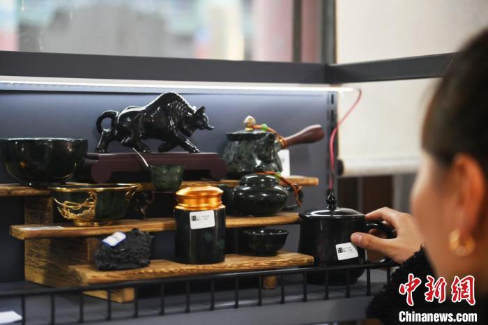 2025年2月8日,甘肃省兰州市城关区“非遗年货购物月”活动现场,游人挑选夜光杯雕茶具。中新社记者 李亚龙 摄