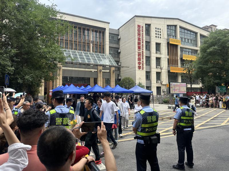 首场语文考试结束，考生陆续走出考场，家长纷纷举起手机记录（记者 程静摄）