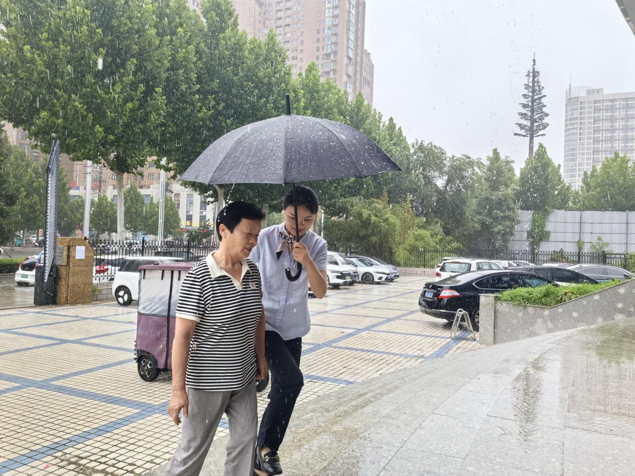 商丘移动归德路营业厅工作人员冒雨迎接前来办理业务的老人