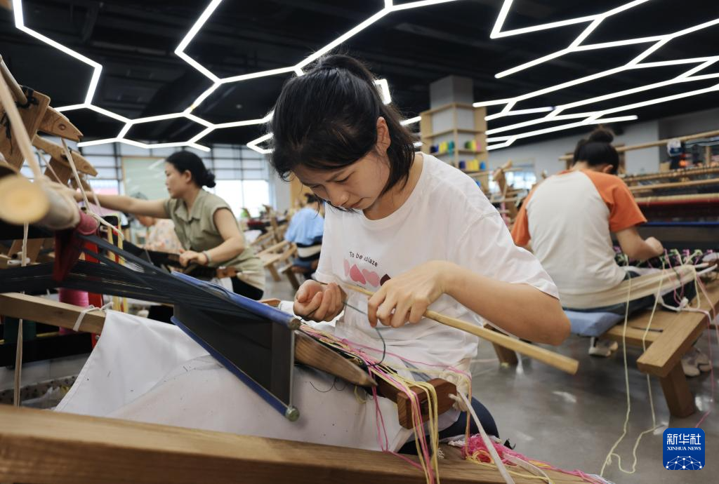 6月9日，在张家界市乖幺妹土家族织锦文化创意园，工人在制作土家族织锦产品。