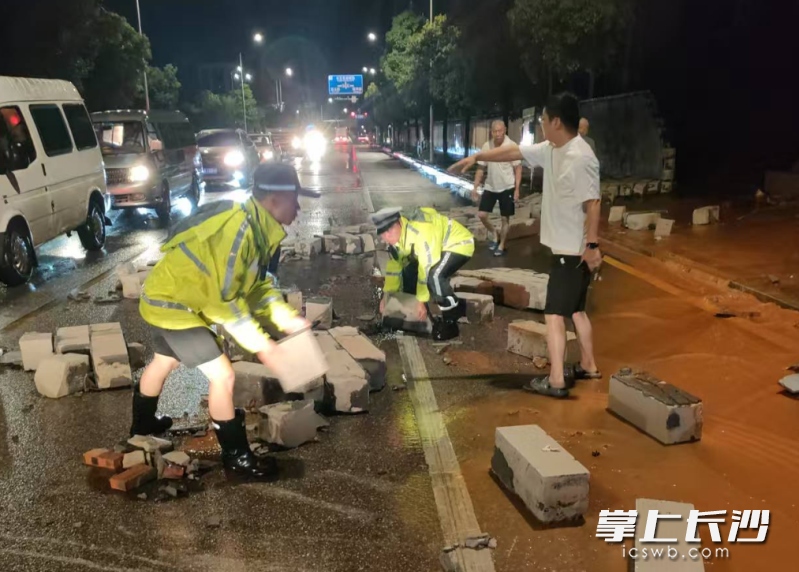 巡逻警力全力“搬砖”,让道路交通得以快速恢复通畅。长沙晚报通讯员 杨哲 供图