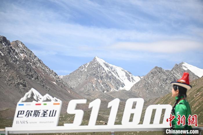 6月17日，位于甘肃省张掖市肃南裕固族自治县巴尔斯雪山景区内，游人身着裕固族服饰走过。中新社记者　李亚龙　摄