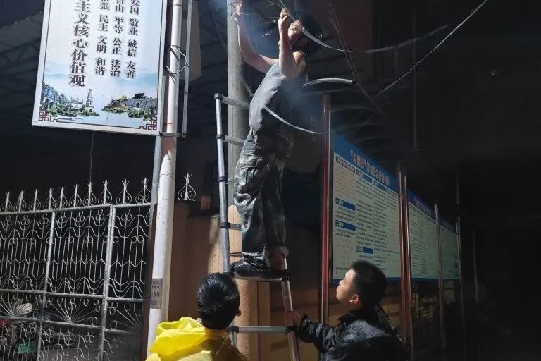图|崖城村党员干部开展夜间巡查工作并维护电线、清理路面树枝等。