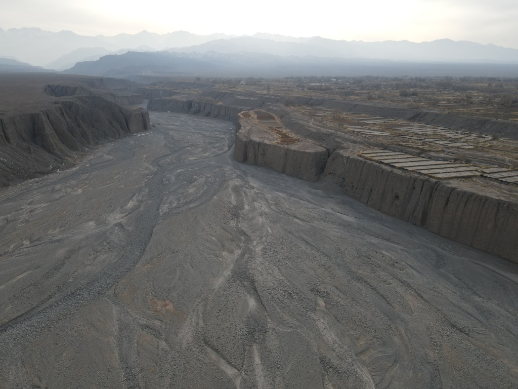 图3 洪水河巨堑及其西岸耕地村庄,崖壁可见明清洞子渠水平导洞洞口。嘉峪关市融媒体中心外宣中心主任 高翔 摄