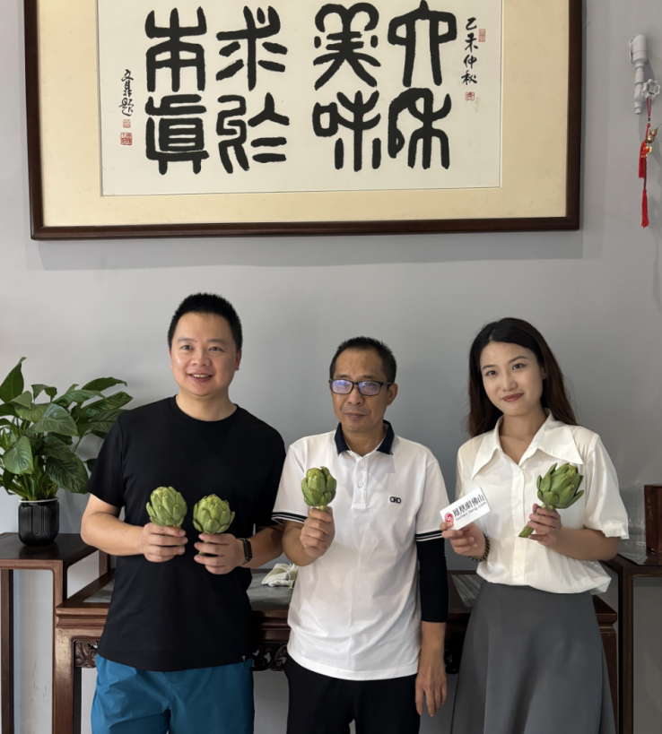 方翔（左）与林雪波（中）手持洋蓟花与工作人员合影。