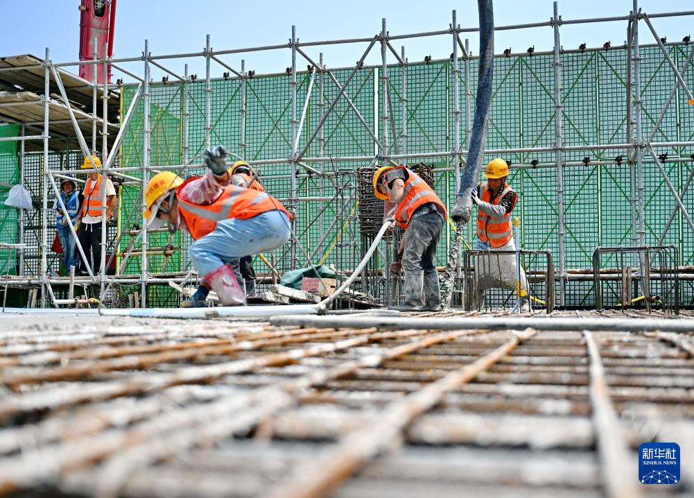 6月18日，中铁建设集团工人在雄忻高铁望都北站建设现场浇筑水泥。