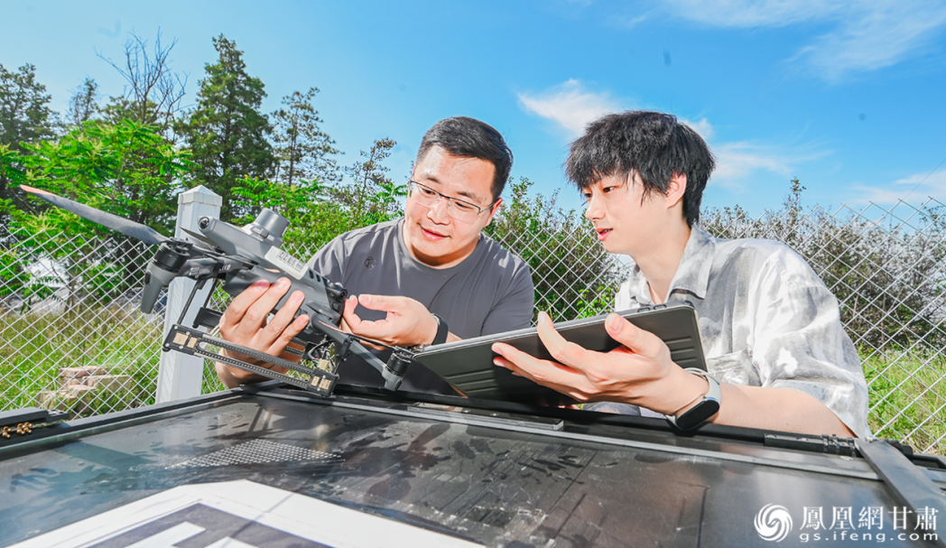 兰州大学博士研究生郅朋（左）与硕士研究生胡成辉检查布设在林场的无人机自动巡检系统　张修毅　摄
