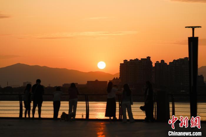 6月16日傍晚，江西南昌上空落日美景，晚霞满天，不少民众来到朝阳江滩公园欣赏晚霞美景。中新社记者 刘思伟 摄