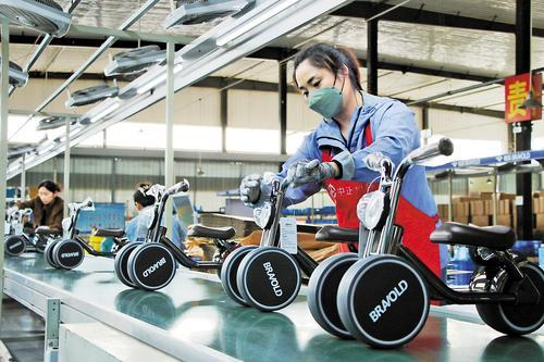 3月20日，邯郸市曲周县亿航童车工人在装配线上组装童车。 刘学维摄
