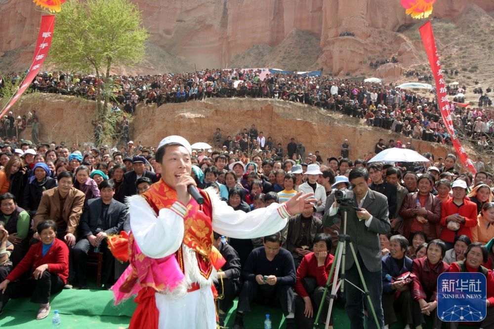 2006年4月25日，人们在甘肃省临夏回族自治州永靖县“罗家洞花儿会”上听歌手唱“花儿”。